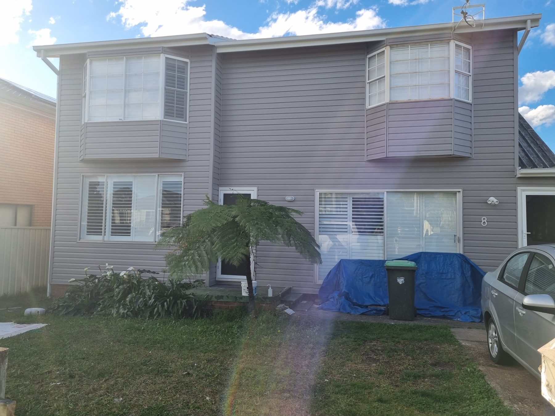 After: Two-storey home re-clad in grey vinyl weatherboards